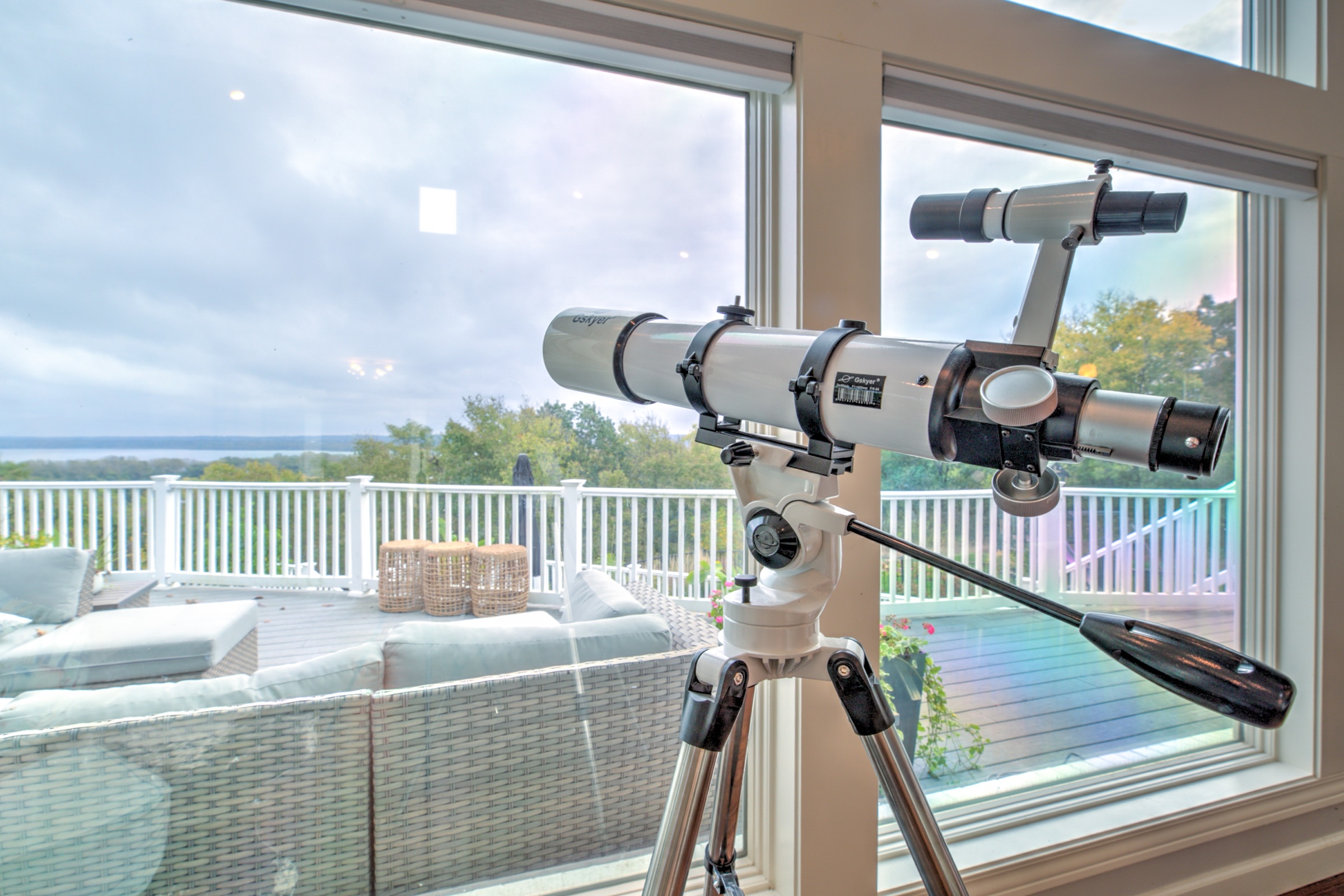 Telescope positioned beside broad windows overlooking the elevated deck and Illinois River Valley