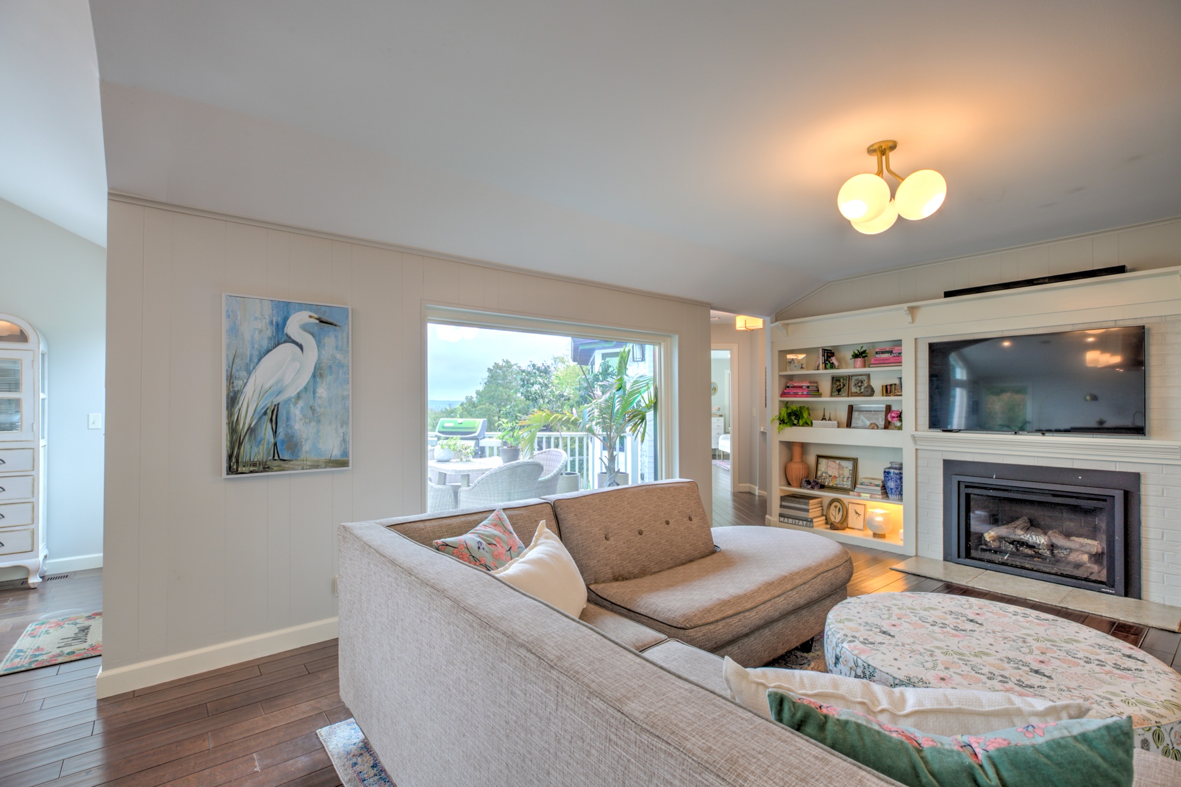 Family room with a fireplace, built in shelving, and direct connection to the elevated deck