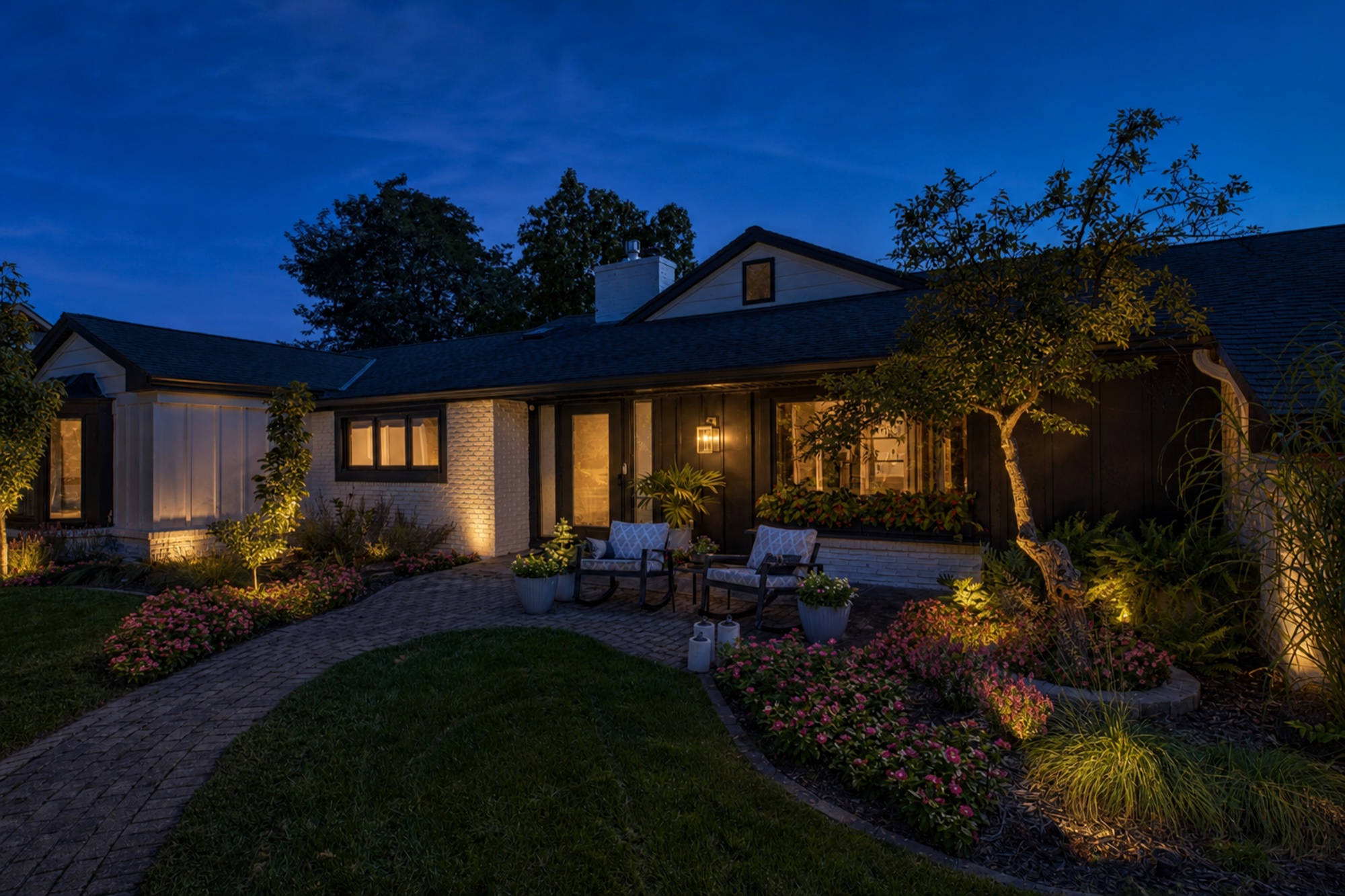 Landscaped front approach and illuminated exterior of the home at twilight